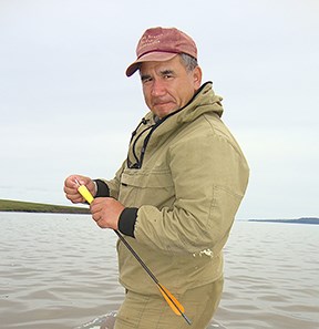a man with a dart with coastal landscape in the background
