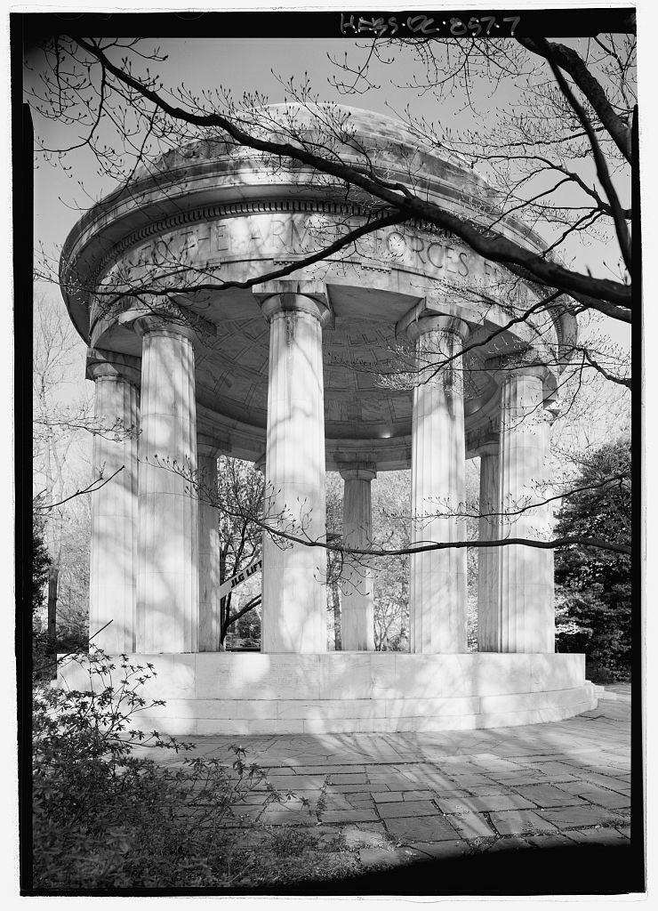 View was photographed looking up at the structure from the turf. Tree branches with early spring buds cast a shadow on the white marble of the memorial.