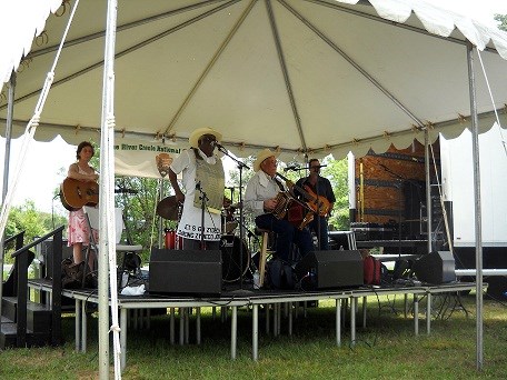 Goldman Thibodeaux and the Lawtell Playboys perform on stage under a tent