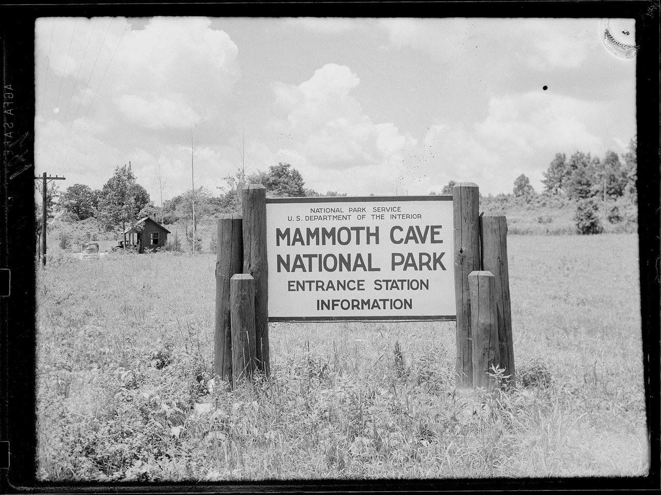 A sign on wooden posts says "Mammoth Cave National Park Entrance Station Information"