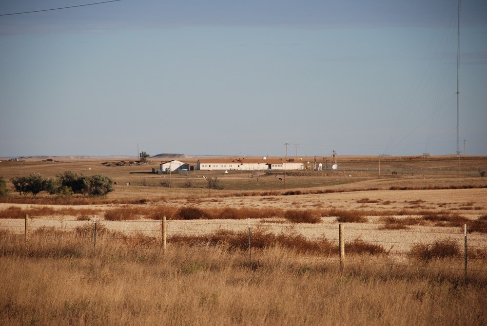 A view of the Delta-01 compound in the distance, surrounded by open ranch land of dry grasses