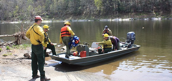 firefighters using a boat to go to a prescribed fire