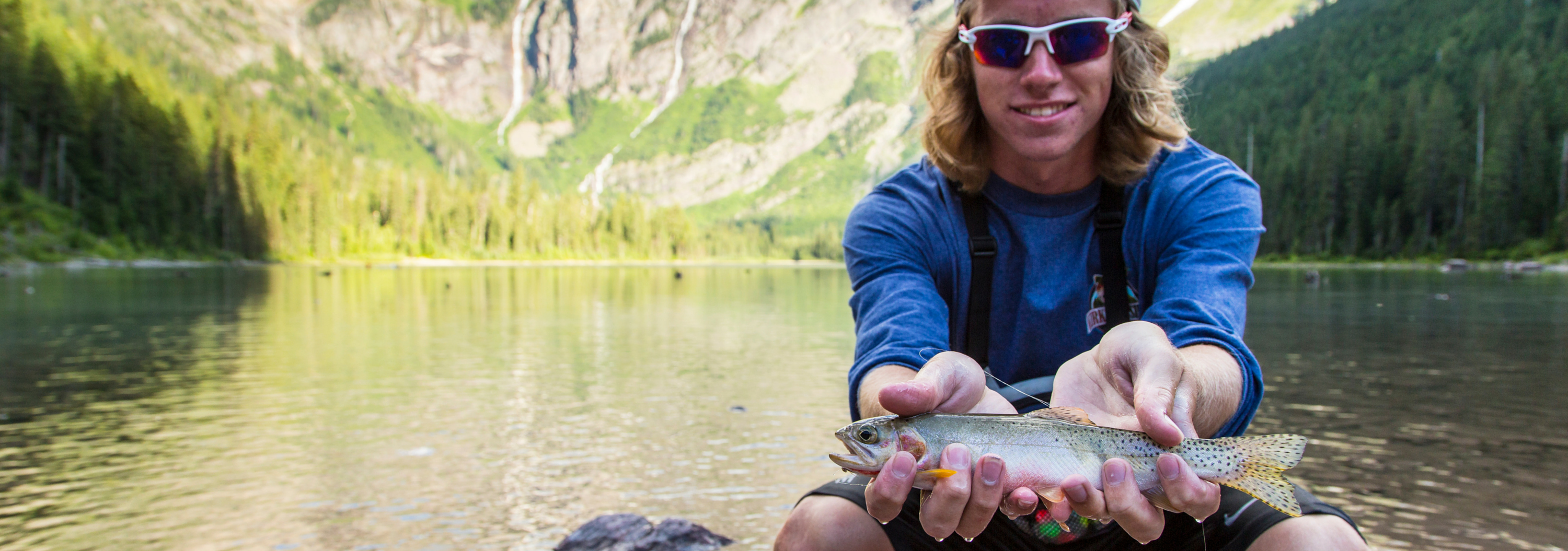 A man holds a fish at Glacier National Park.