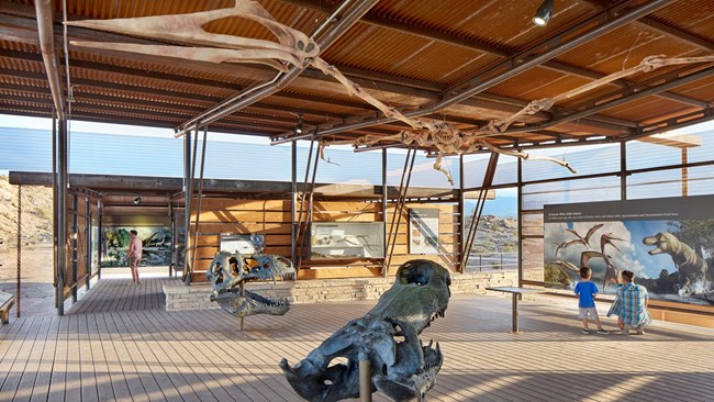 BIBE 85932E8F-1DD8-B71B-0B64AEFB00A36603 Photo of the inside of a fossil site visitor center with murals and castings of bones.
