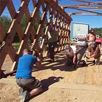 Color photo of people constructing a floor system for a covered bridge