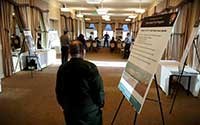 public-involvementinfrastructure a man walks by a planning meeting agenda sign as he enters room
