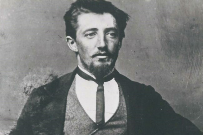 lt= Historic black and white photo of man with black hair in black jacket