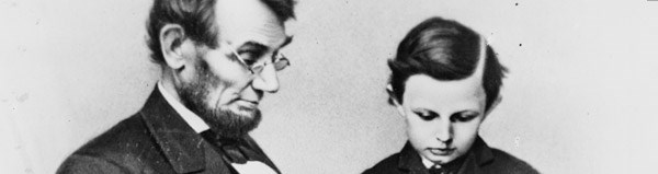 Abraham Lincoln and son, Tad, reading.