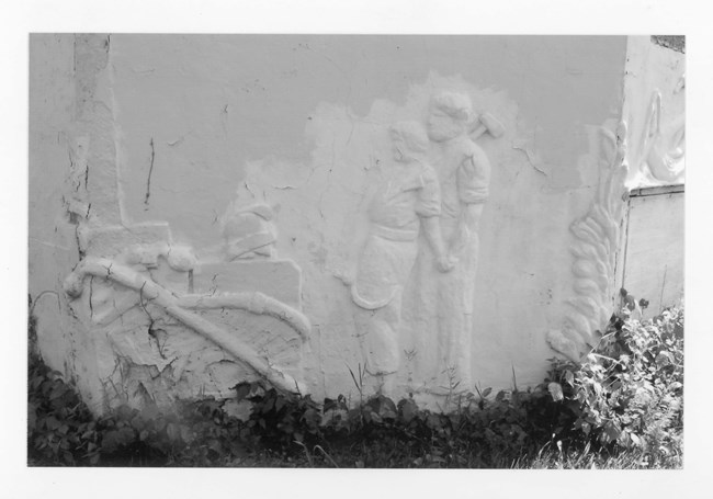 Wall of bulding showing figurative bas-relief of a man and a woman