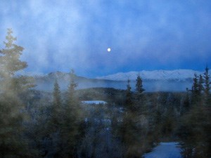 Fog shrouds this view of a rising moon over Healy Ridge in Denali National Park and Preserve.