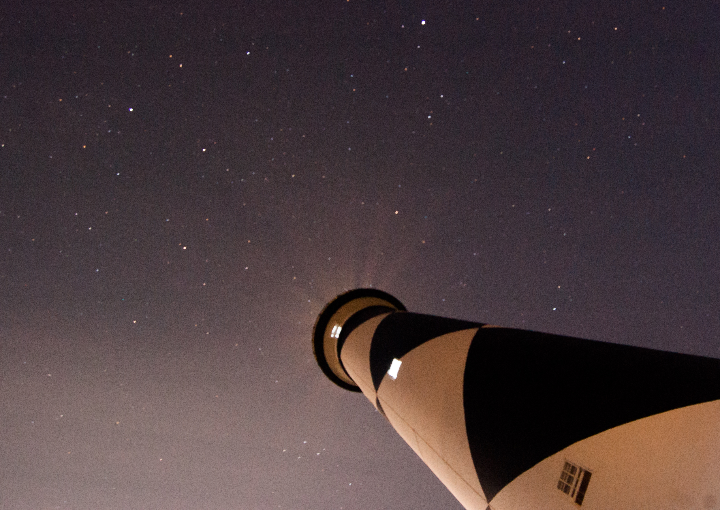 The starry night sky above the Cape Lookout Lighthouse