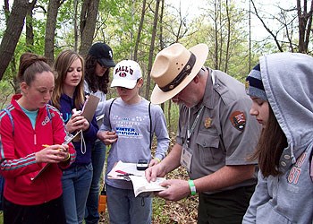A park ranger and young adults identify species during a BioBlitz species inventory.