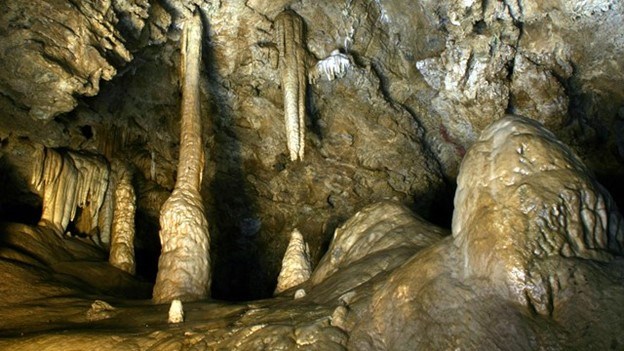 Tan rocks appear to be dripping in these cave formations of stalactites and stalagmites.