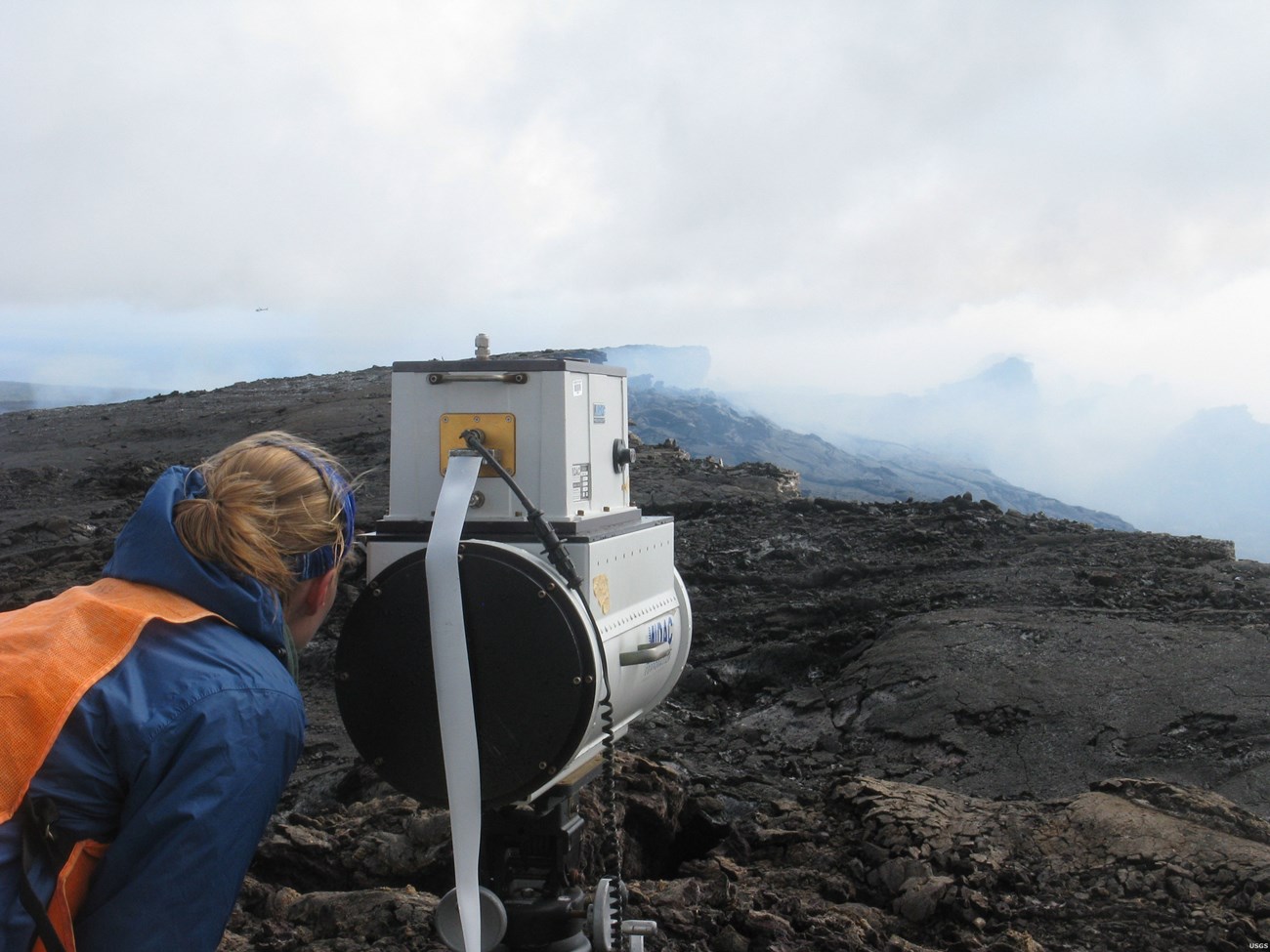 Photo of a person looking through a monitoring instrument.