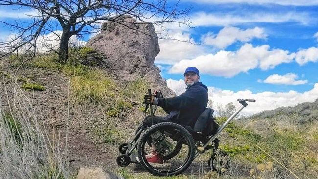 A wheelchair user takes in the hillside view.