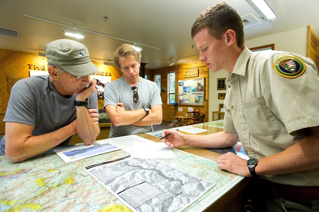 Park visitors Aaron and Richard Hoff seek advice at the Wilderness Information Center. August 28, 2012, Marblemount, Washington, Campers get an update on backcountry conditions from a park volunteer at NPS by Davi