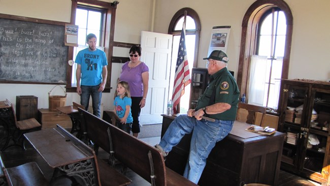 volunteer providing information to visitors at the one room schoolhouse