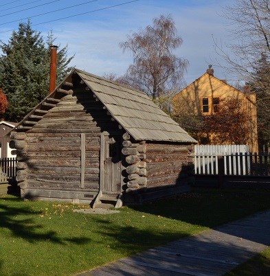 Modern photo of log cabin with green graass