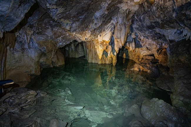 A pool of water surrounded by cave formations