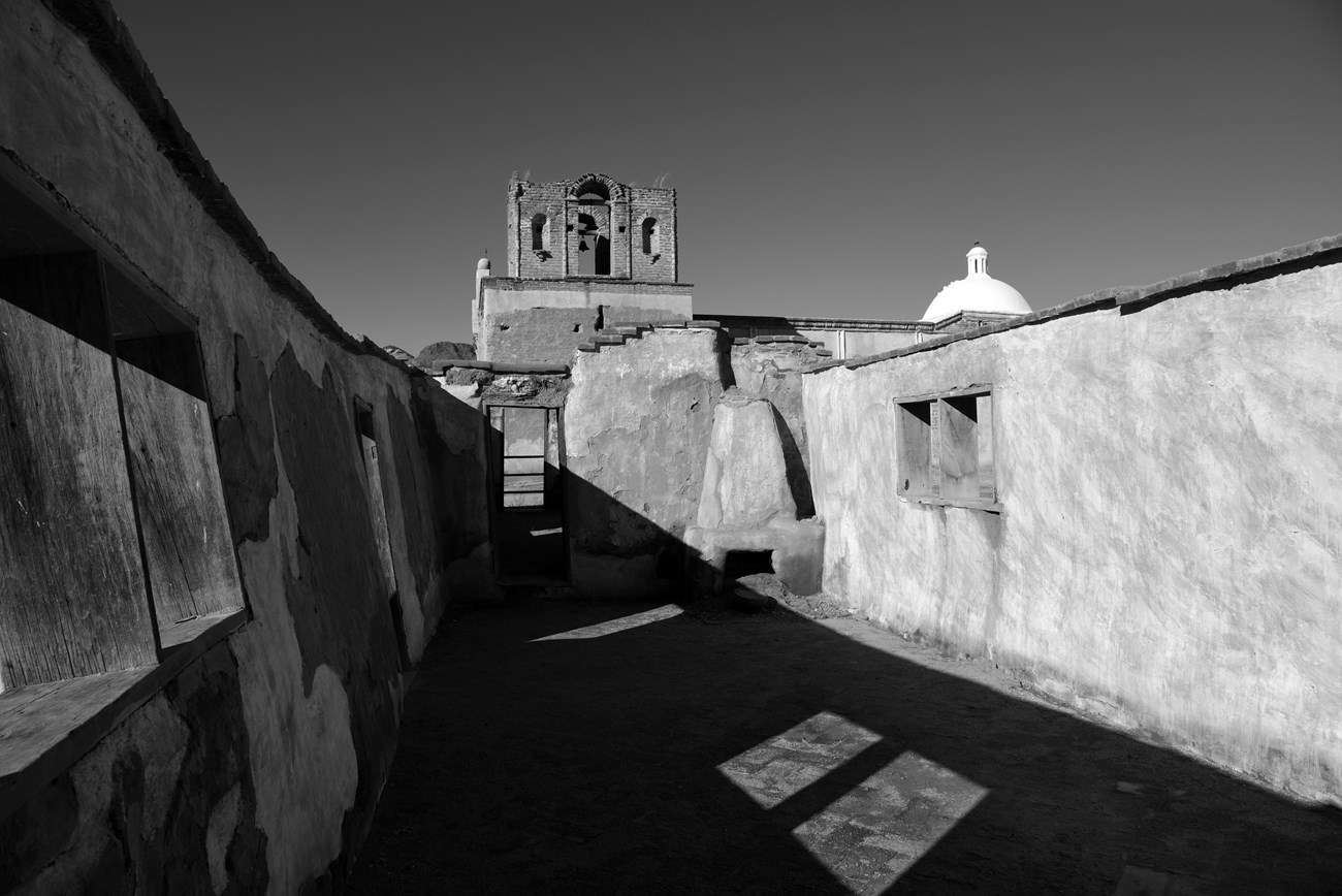 Black and white photograph of historical adobe buildings.