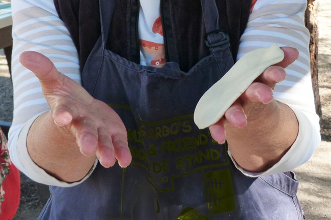 Corn tortillas-handling2 Hands flipping corn tortilla back and forth.