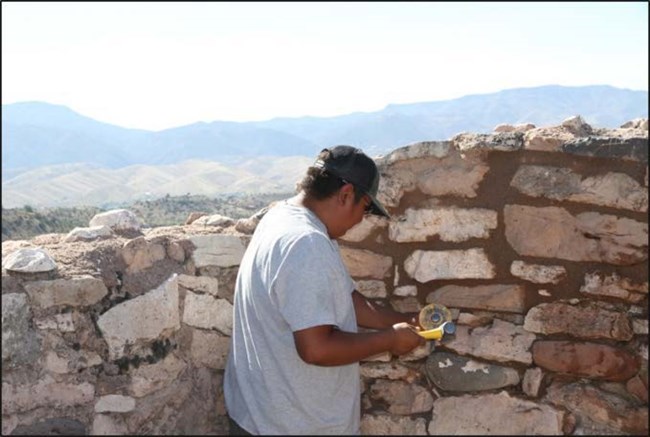 Preservation Mason removing portland cement by hand to preserve the original fabric of the wall.