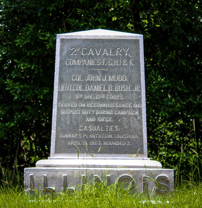 A granite slab with an inscription and Illinois listed in larger font at the bottom of the marker