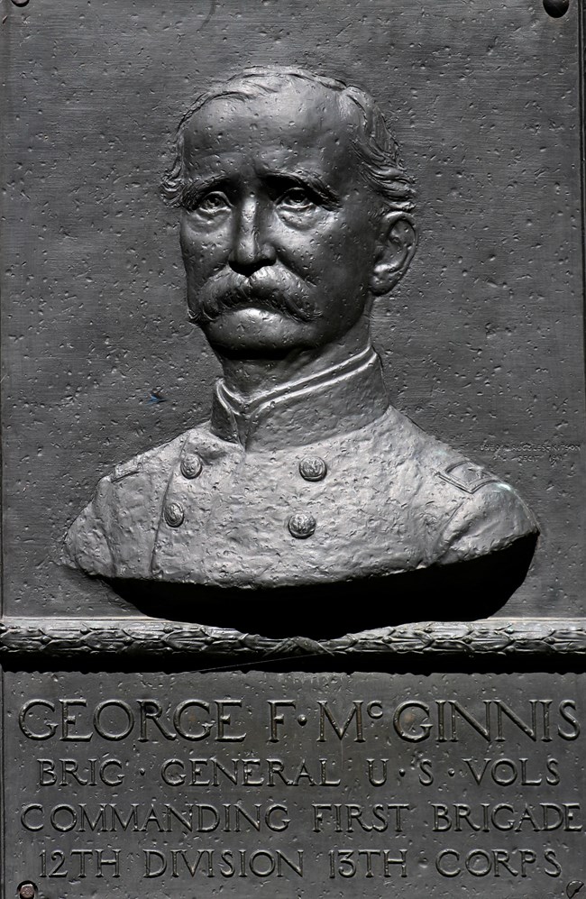 A bronze tablet with a sculpted relief portrait of a man in uniform