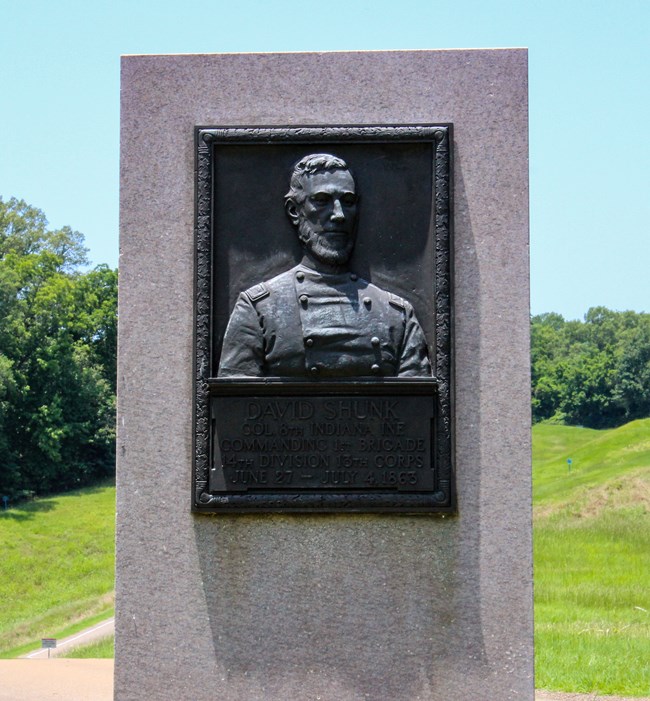 A bronze relief sculpture of a man in uniform