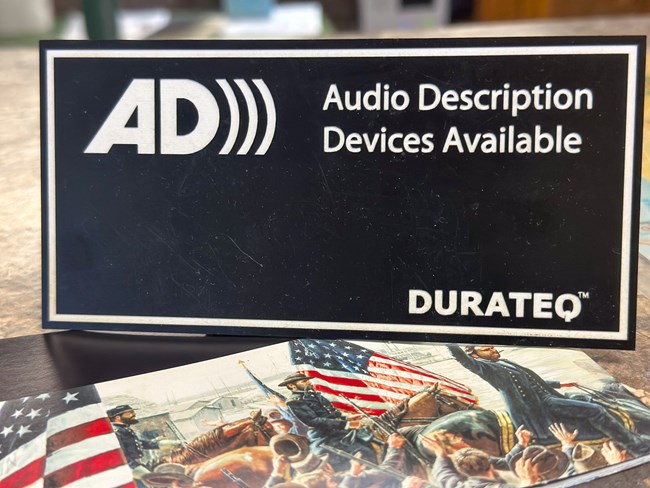 A sign saying Audio description devices available