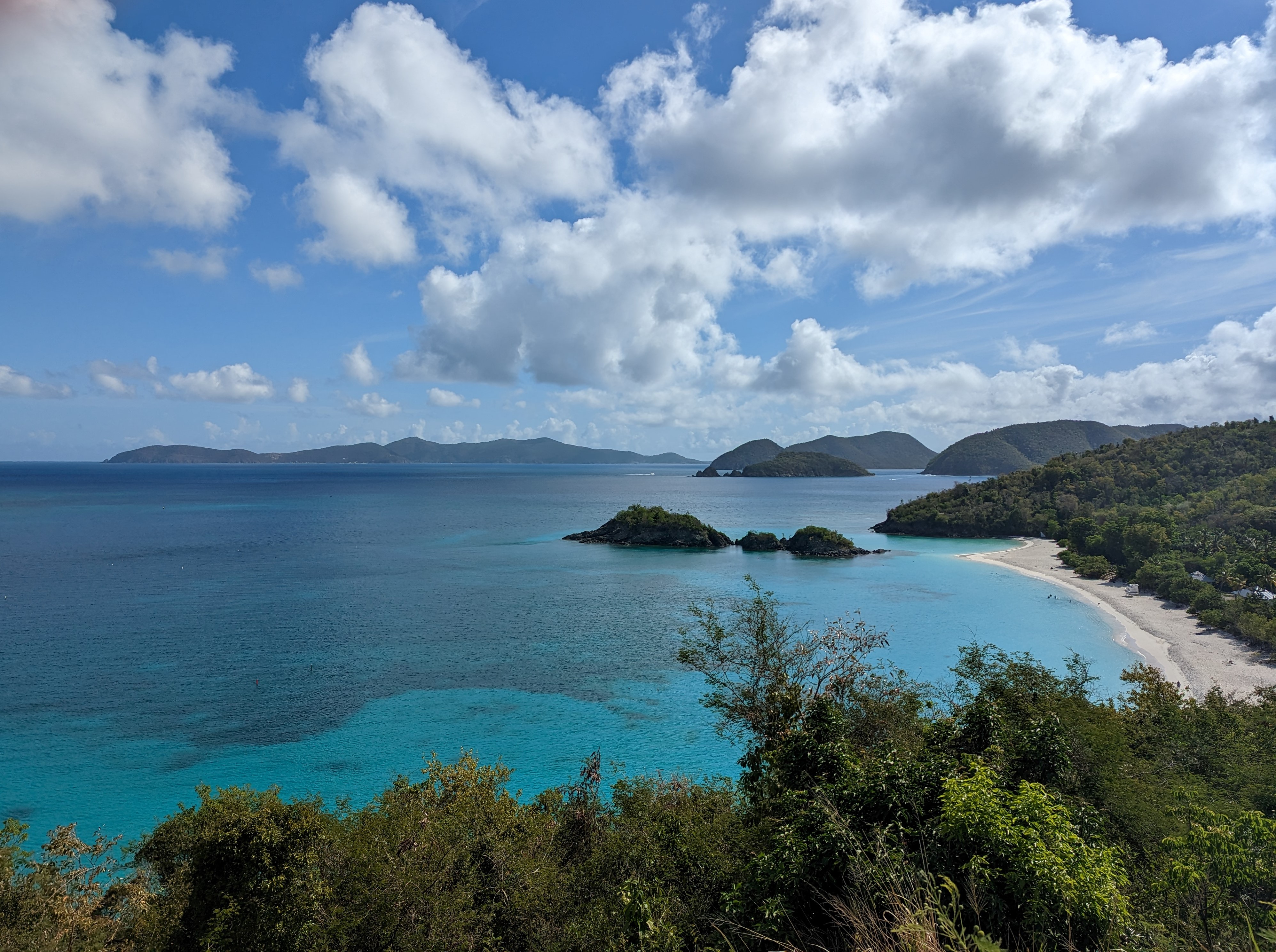 Image of Trunk Bay with white sand, green hills and blue water.