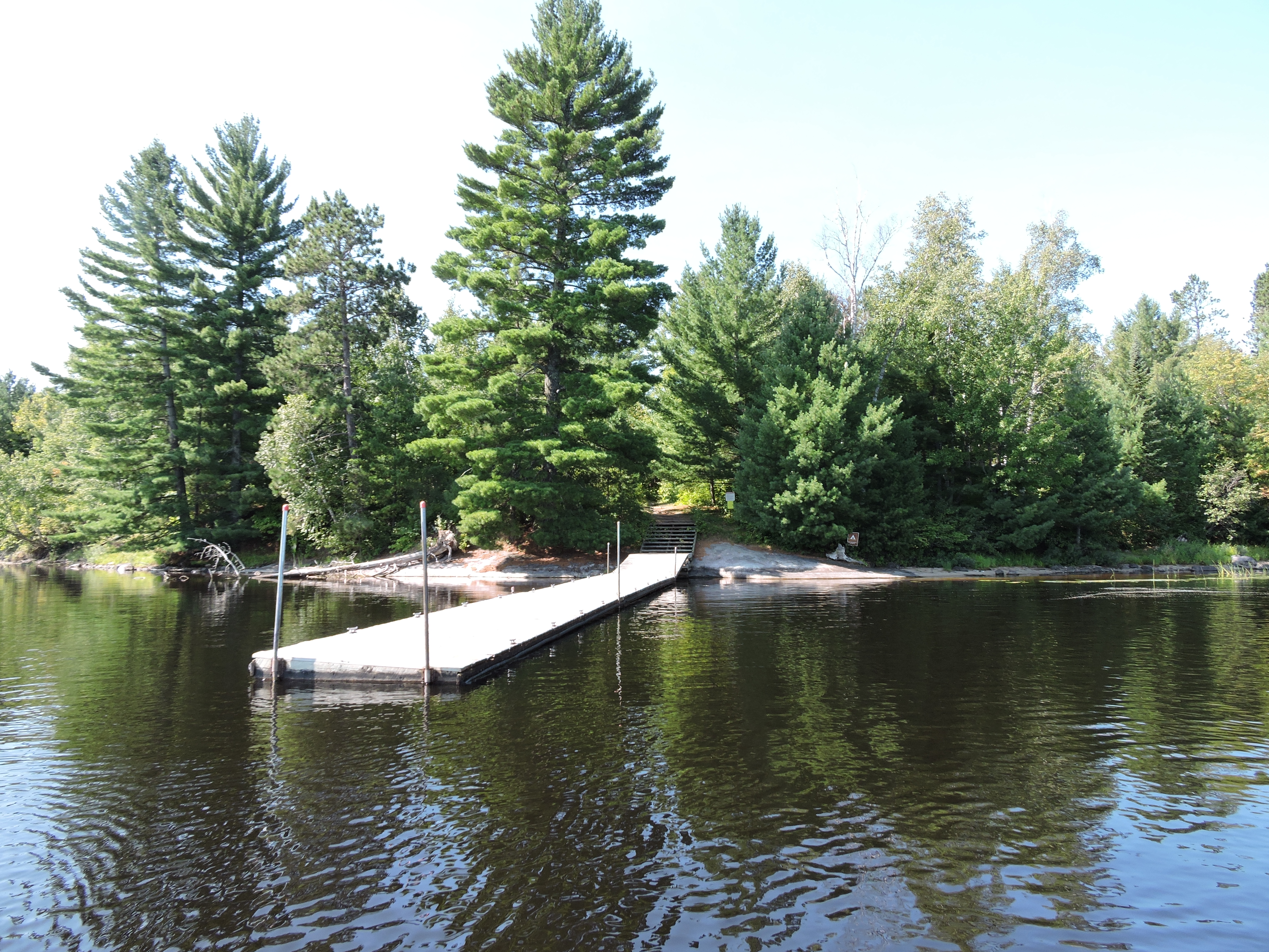 A dock in the water with a trail behind it.