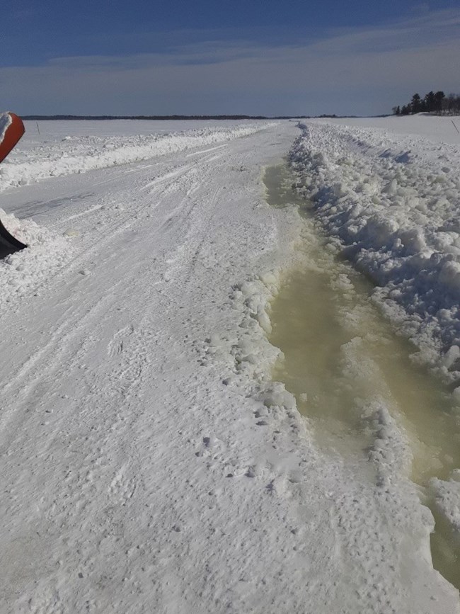 water and slush on the surface of a plowed ice road