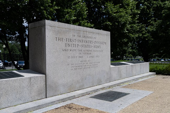 WHHO_Monuments_20250515_NKing_015 A large, rectangular monument with a low, angled wall with bronze plaques on it.
