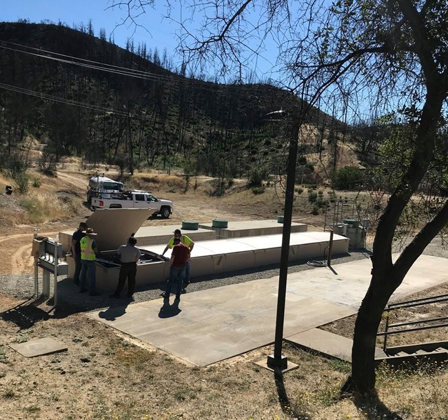 Park staff finishing up the installation of Oak Bottom's new wastewater processing plant.