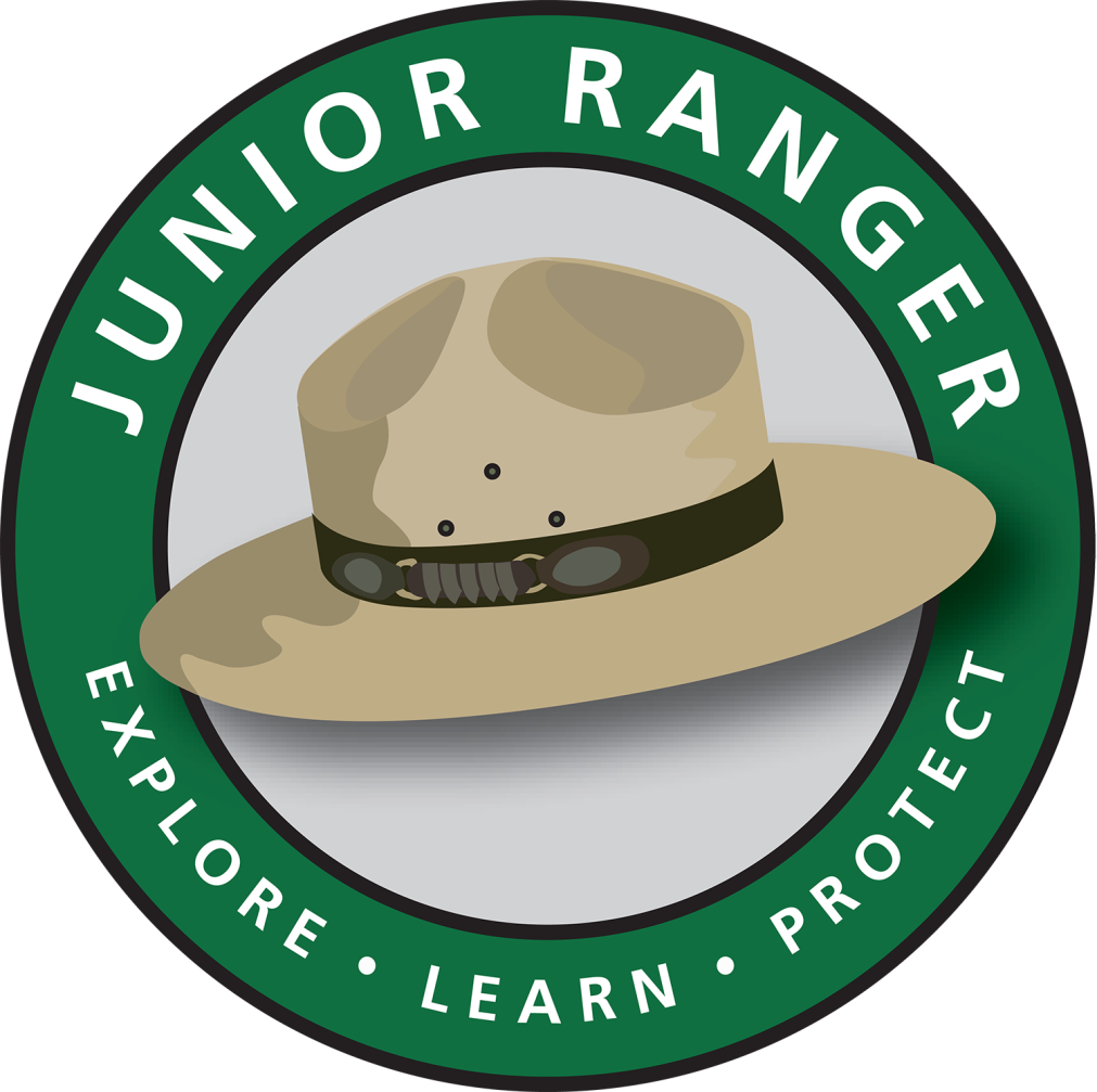 a green cirle with white lettering that reads Junior Ranger Explore Learn Protect inside the circle is a color drawing of a ranger hat