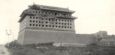 A large chinese building showing facade damage near the roof built of stone