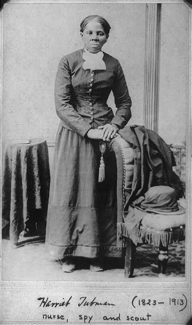 Harriet Tubman standing next to a chair