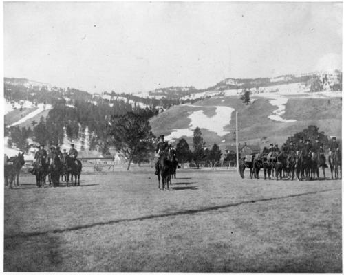 YELL9739 Images of military men on horseback in a field, with snowy mountains in the background.