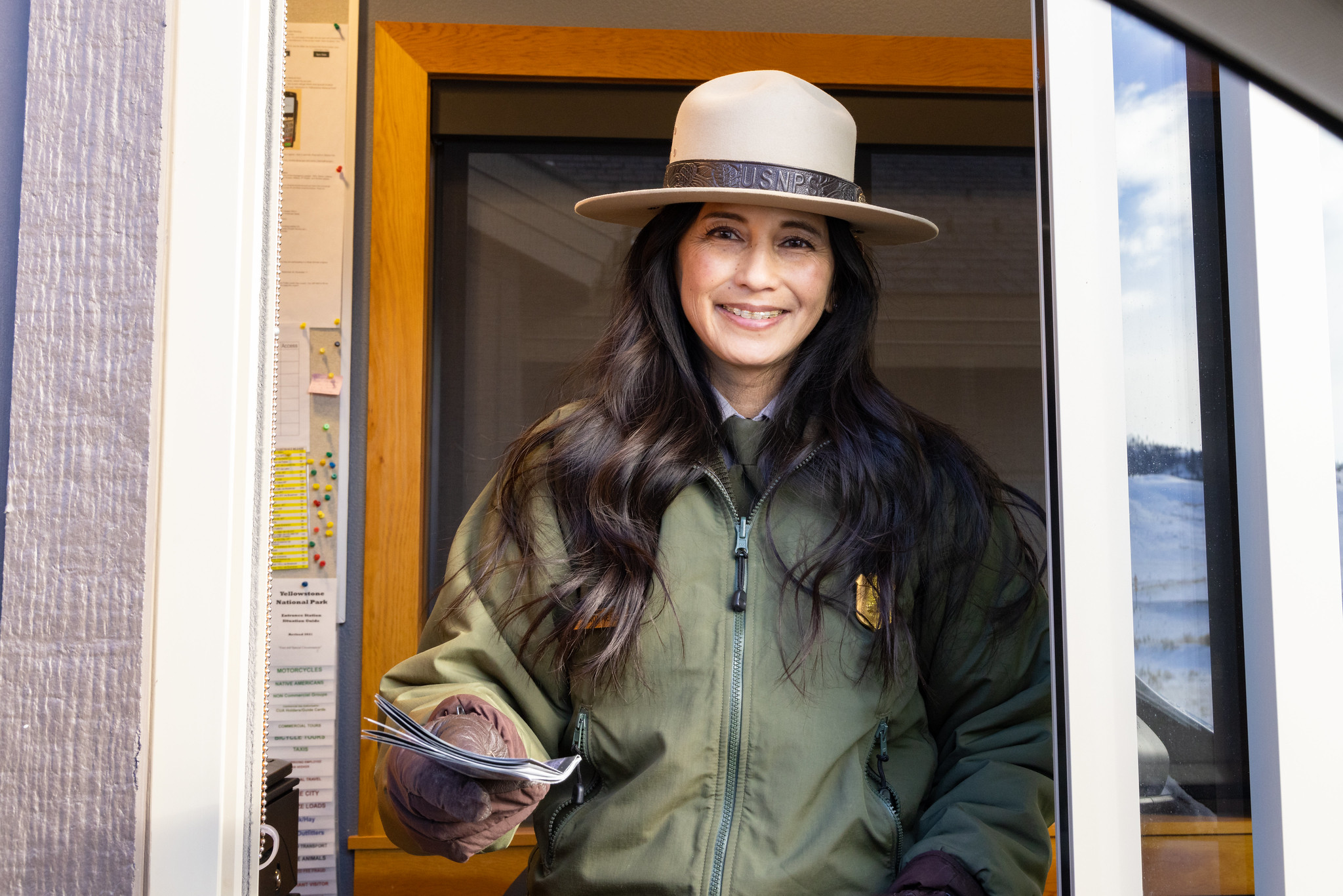 ranger hands out newspaper at entrance gate