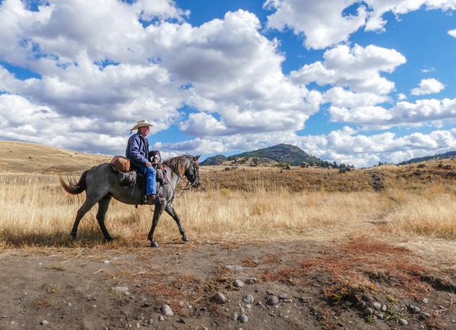 Horseback rider with blue sky and clouds Horseback rider with blue sky and clouds