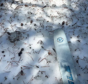 Textured and littered snow (with tree debris) on March 22, 2026.