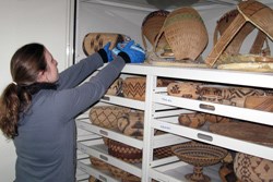 Museum employee working with historic baskets