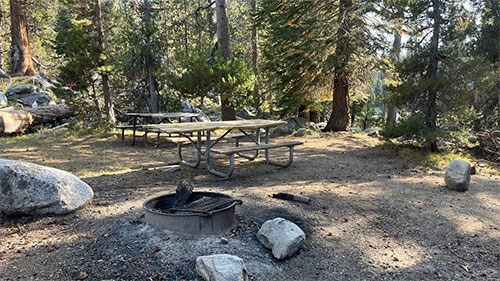 Yosemite Creek Picnic Area with picnic table, granite rocks, and a fire pit.