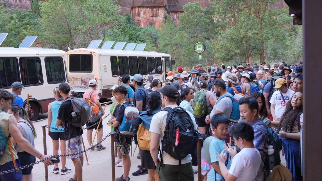 A long line of visitors wait for the Zion Canyon shuttle