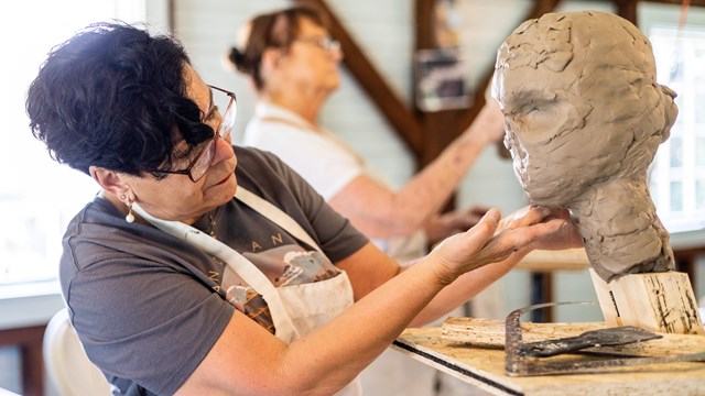 artist sculpting clay bust