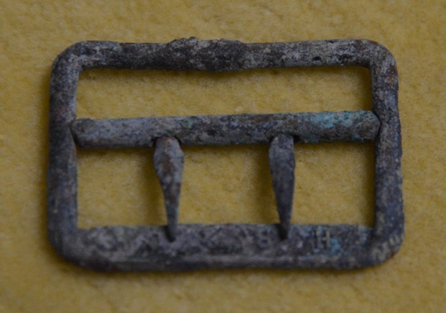 Metal buckle with two prongs and green corrosion