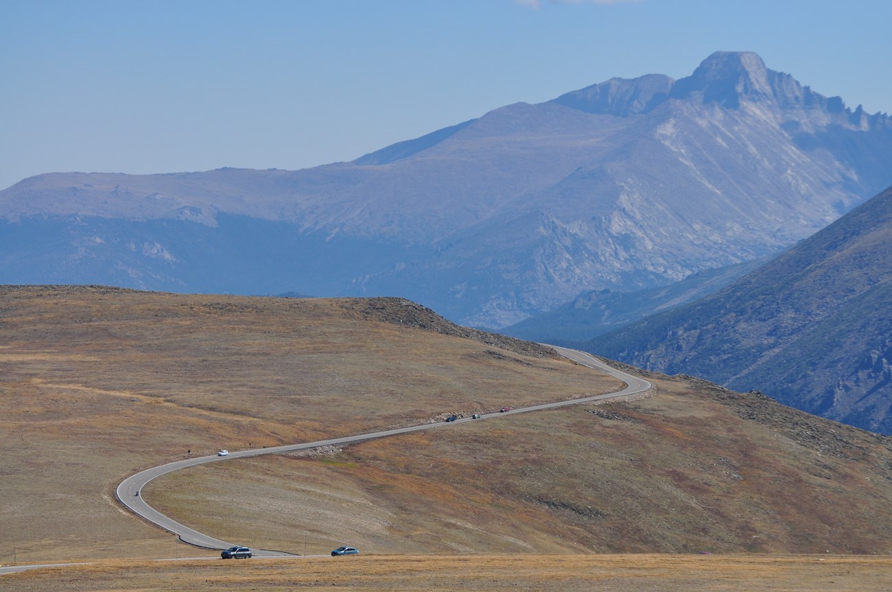 View of cars driving along the Tundra Curves on Trail Ridge Road above tree line